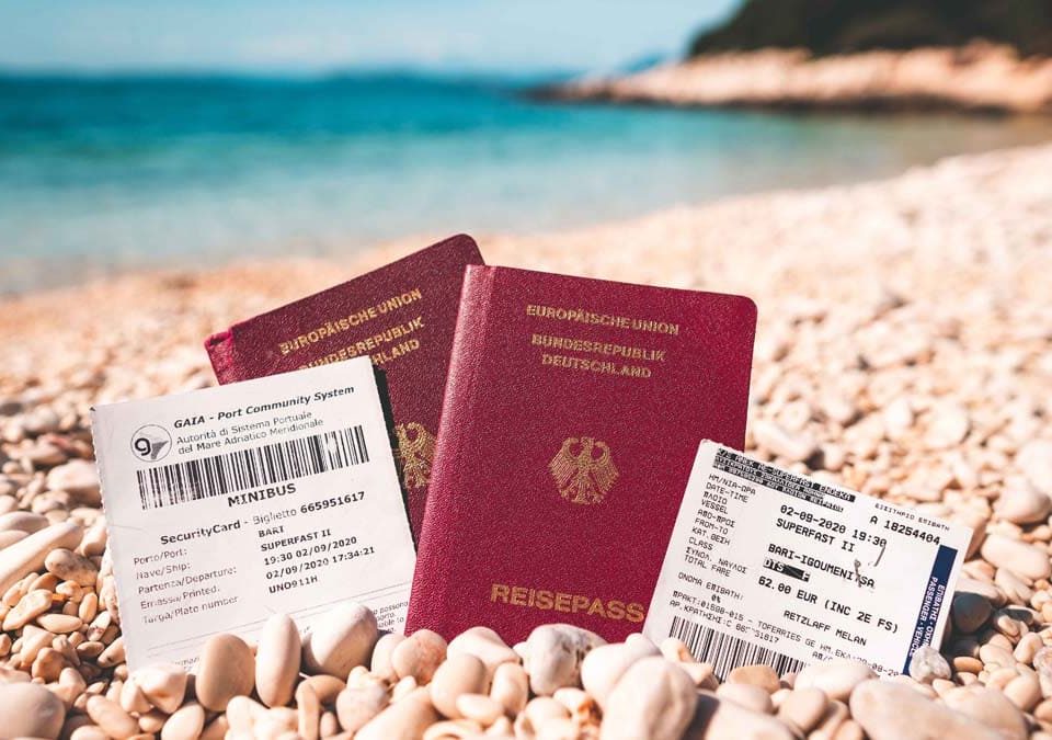 Reisepass mit Fährtickets am Strand für die Einreise nach Griechenland